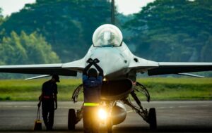 Ground crew inspects jet fighter at Jakarta airbase, morning light