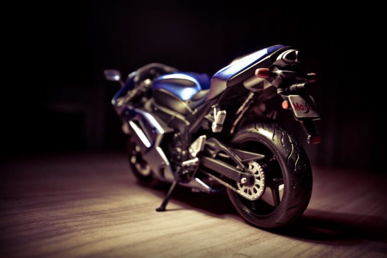 Artistic close-up of a blue sports motorcycle indoors, dramatic lighting accentuates its sleek design.