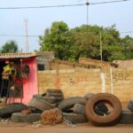Roadside tire shop with worn tires and brick wall, Senegal.