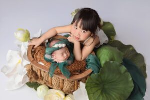 Cute portrait of two siblings in a lotus-themed studio setup in Vietnam.