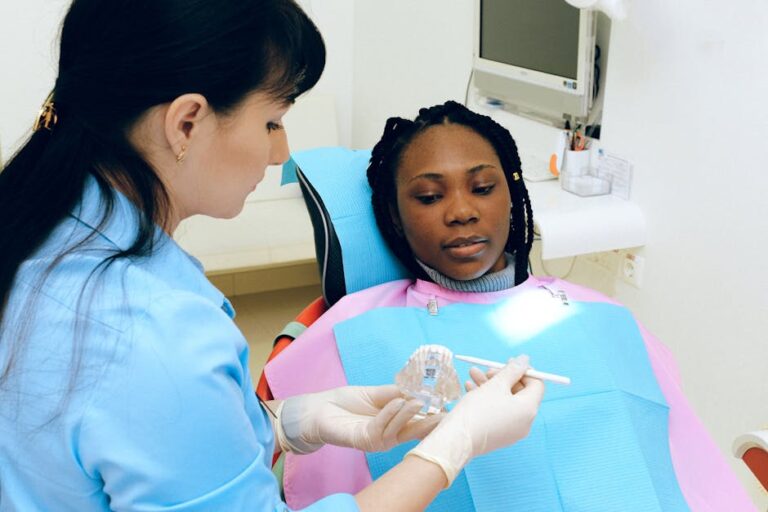 Dentist explaining procedure to patient during dental check-up in clinic setting.