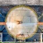 Top view of huge industrial tanks connected with rusty passages located at territory of factory