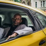 Middle aged African American male in business suit looking away while going by taxi