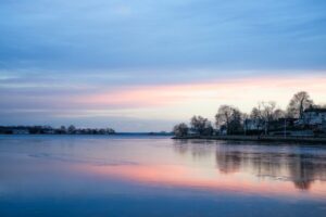 Tranquil winter sunset reflecting on a frozen waterfront landscape.