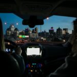 View of city skyline during night drive, captured through car windshield.