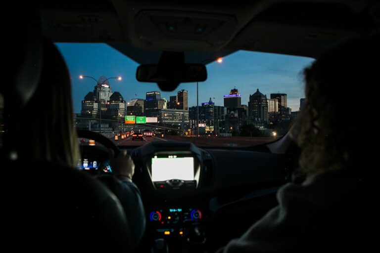 View of city skyline during night drive, captured through car windshield.