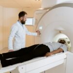 A doctor operates an MRI machine with a patient undergoing a scan in a medical facility.