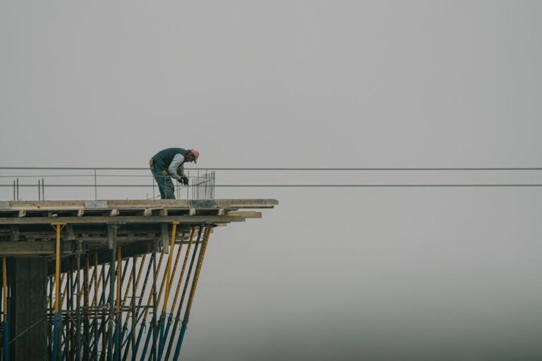 Worker on construction site framework against a cloudy sky in Denizli, Türkiye.