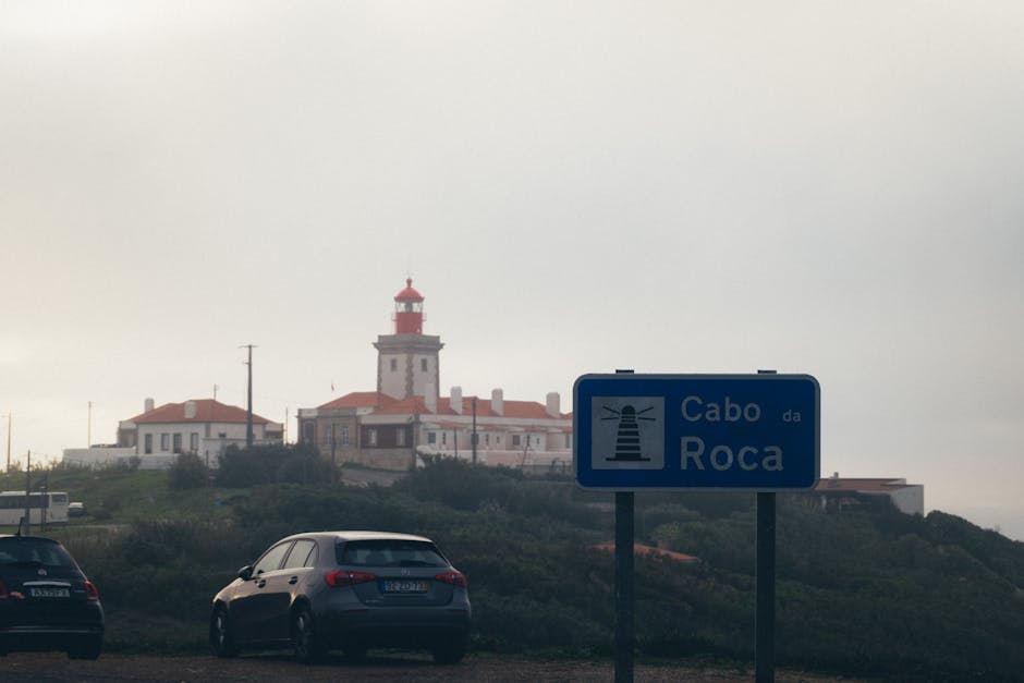 Lighthouse at Cabo da Roca with a road sign in foreground, Portugal's westernmost point.