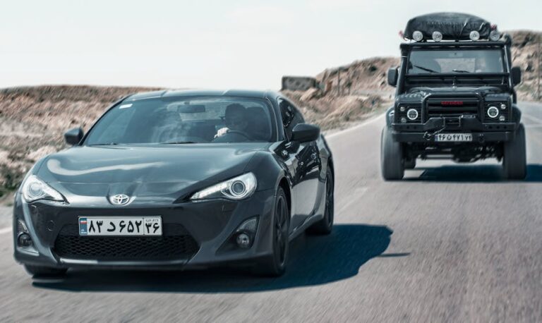 Action-packed shot of a Toyota sports car and Jeep driving on an open road.