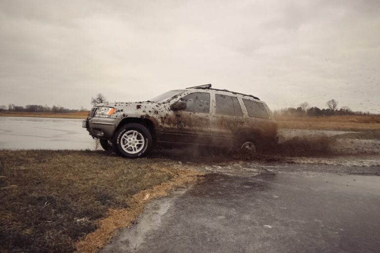 SUV navigating muddy terrain showcasing off-road capabilities in a rural setting.