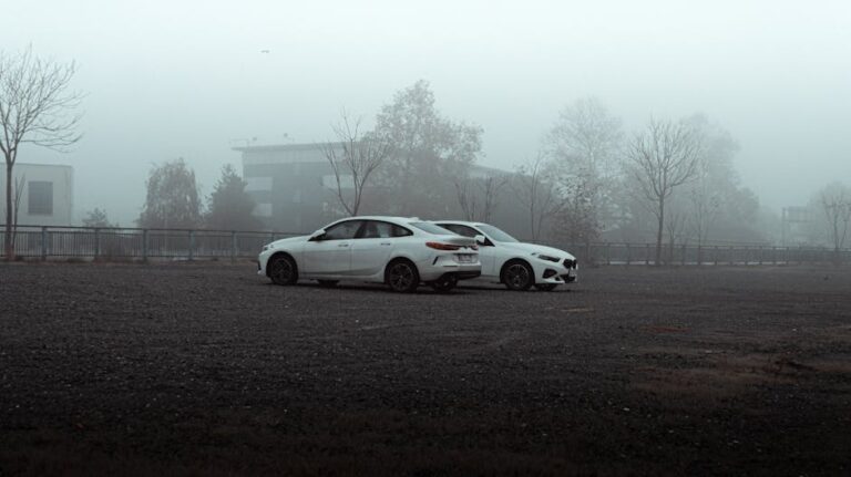 Two white cars parked in a foggy, empty urban Istanbul area, capturing a misty atmosphere.